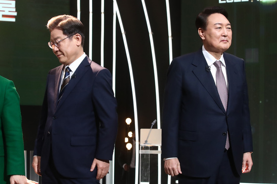 (서울=뉴스1) 국회사진취재단 = 3일 오후 서울 여의도 KBS 공개홀에서 열린 <방송 3사 합동 초청> 2022 대선후보 토론에서 이재명 더불어민주당 대선 후보가 기념촬영을 마친 뒤 자리로 돌아가고 있다. 오른쪽은 윤석열 국민의힘 대선 후보. 2022.2.3/뉴스1  
