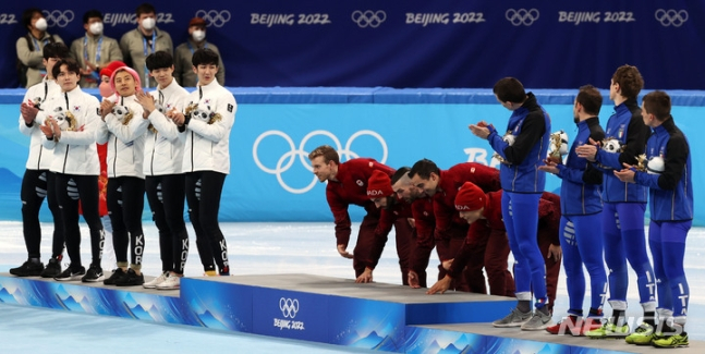지난 16일 오후 중국 베이징 캐피털 실내경기장에서 열린 2022 베이징동계올림픽 쇼트트랙 남자 5000m 계주 결승에서 금메달을 획득한 캐나다 선수들이 플라워 시상식에서 시상대 오르기 전 바닥을 쓰는 세리머니를 하고 있다. /사진=뉴시스