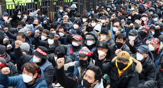 (서울=뉴스1) 장수영 기자 = 민주노총 전국택배노동조합 조합원들이 25일 서울시 청와대 앞에서 CJ대한통운 택배 대리점연합회와의 협상결과 기자회견에 앞서 집회를 갖고 있다.   택배노조와 대리점연합회는 사흘째 대화를 이어갔지만 협상에 난항을 겪고 있는 것으로 알려졌다. 2022.2.25/뉴스1   