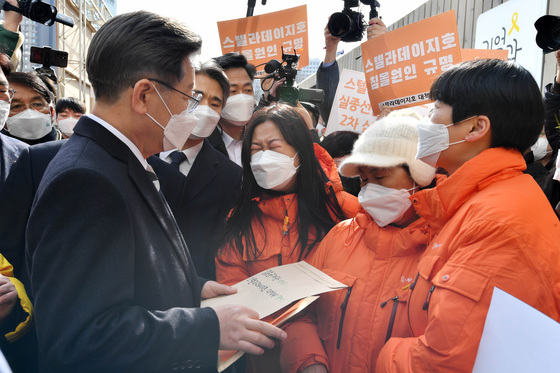 (서울=뉴스1) 국회사진취재단 = 이재명 더불어민주당 대선 후보가 9일 오후 서울 중구 서울시의회 앞 '임시 기억공간' 마당에서 열린 '지워진 사람들-대구지하철참사 19주기 추모식 및 생명안전 국민약속식'에서 스텔라데이지호 침몰 사고 희생자 가족들의 호소를 듣고 있다. 2022.2.9/뉴스1  