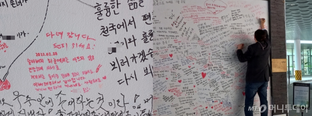 17일 오전 9시쯤 서울추모공원 입구 앞에 있는 '바람이 머무는 동안에'라는 추모 벽에 한 남성이 고인을 애도하는 글을 적고 있다. /사진= 양윤우 기자