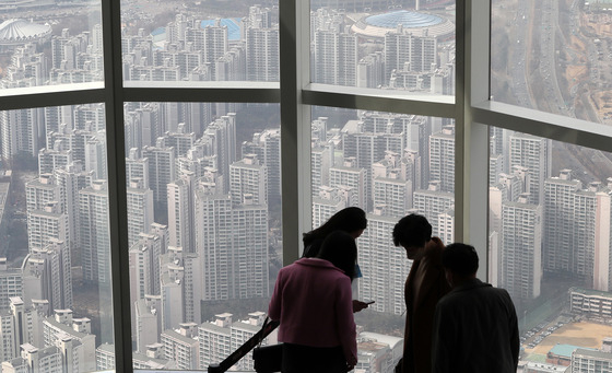 (서울=뉴스1) 박세연 기자 = 10일 오후 서울 송파구 롯데월드타워 서울스카이를 찾은 관람객이 아파트단지를 바라보고 있다. 윤석열 국민의힘 후보가 제20대 대통령으로 선출됐다. 야당 소속의 후보가 당선되면서 부동산 정책 기조의 큰 변화가 예상된다. 문재인 정부가 추진한 공공주택 중심의 주택 공급보다 재건축 재개발 등 민간 분야 규제 완화를 통한 주택 공급이 원활할 것으로 보이며 공약 등을 통해 종부세의 장기적 폐지를 예고했다. 또 오세훈 서울시장과의 정책 공조로 서울 주택 공급이 늘어날 전망이다. 윤석열 당선자는 공약을 통해 5년간 전국 주택 250만 가구를 공급하겠다고 밝혔다. 수도권은 서울 50만 가구를 포함, 150만 가구를 공급하겠다는 게 목표다. 2022.3.10/뉴스1