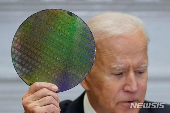  미국 워싱턴 백악관 루즈벨트룸에서 열린 반도체 공급망 관련 회의에서 조 바이든 대통령이 반도체 웨이퍼를 들어보이고 있다./사진제공=[워싱턴=AP/뉴시스]