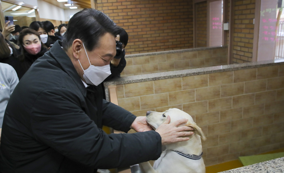 (용인=뉴스1) 국회사진취재단 = 19일 윤석열 국민의힘 대선 후보가 19일 오후 경기도 용인시 처인구 삼성화재 안내견학교를 방문해 장애인 관련 정책공약 발표에 앞서 안내견과 인사하고 있다. 2022.1.19/뉴스1
