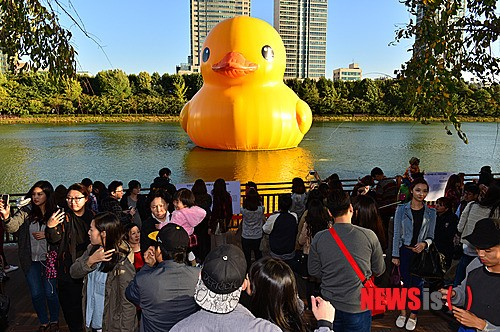 2014년 10월16일 서울 송파구 석촌호수에서 시민들이 1톤짜리 초대형 고무오리 '러버덕'과 기념촬영과 사진촬영을 하고 있다. /사진=뉴시스