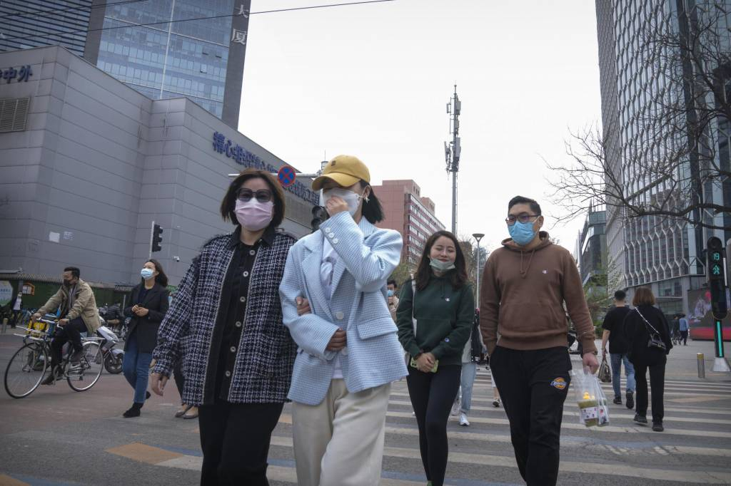 [베이징=AP/뉴시스] 13일(현지시간) 중국 베이징에서 마스크를 쓴 주민들이 교차로를 건너고 있다. 중국 당국이 2년 만에 발생한 최악의 코로나19로 봉쇄를 강화하면서 주요 자동차 회사들과 협력 업체 생산이 타격을 입어 자동차 공급망 혼란이 커지고 있다. 2022.04.13.