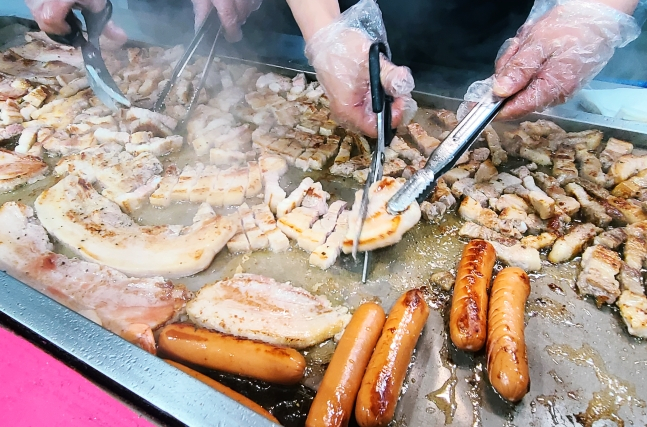 '통밥'에서 삼겹살과 소시지 등을 직접 굽고 있다. /사진=김우종 기자