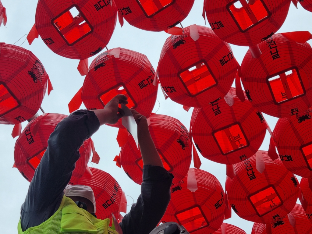 8일 오전 서울 강남구 봉은사 한  자원봉사자가 한 가족의 염원이 적힌 종이를 연등에 달고있다. /사진=조성준기자