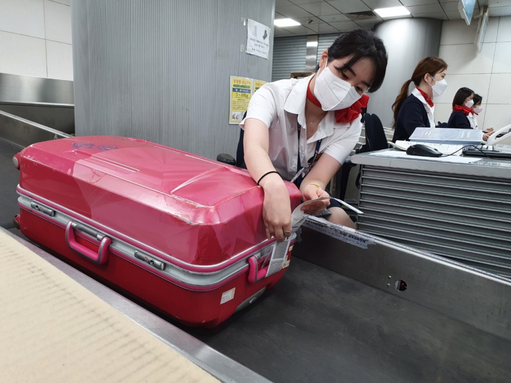 지상서비스를 담당하는 스위스포트코리아 직원이 여행 가방에 수화물표를 부착하고 있다. 