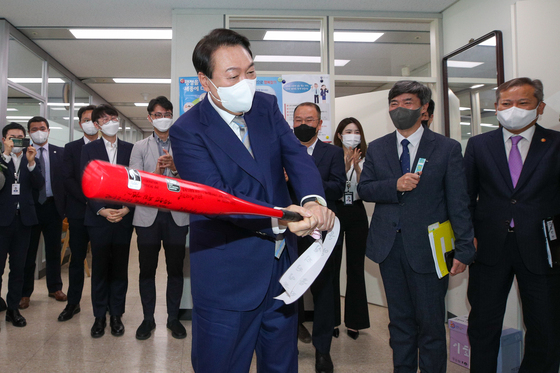 (세종=뉴스1) 안은나 기자 = 윤석열 대통령이 26일 정부세종청사에서 국정운영실 직원으로부터 국정운영 홈런을 기원하는 메시지가 적힌 야구 방망이를 선물받은 뒤 휘두르고 있다. (대통령실사진기자단) 2022.5.26/뉴스1  