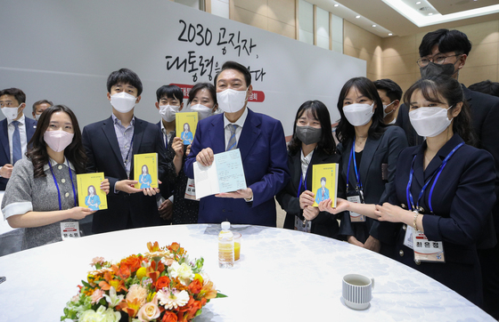 (세종=뉴스1) 안은나 기자 = 윤석열 대통령이 26일 정부세종청사 컨벤션센터에서 열린 MZ세대(2030) 청년 공무원들과의 간담회에서 참석자들로부터 '90년생 공무원이 왔다'라는 책을 선물받고 있다. (대통령실사진기자단) 2022.5.26/뉴스1  