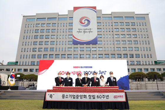 윤석열 대통령이 25일 용산 대통령실 청사 앞 잔디마당에서 열린 2022 대한민국 중소기업인대회에서 기업인들과 함께 중소기업중앙회 창립 60주년 기념떡을 자르고 있다. /사진=뉴스1(대통령실사진기자단)   