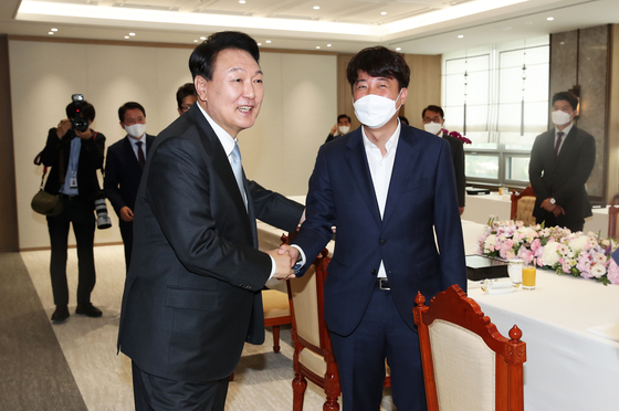 윤석열 대통령(왼쪽)이 10일 용산 대통령실 청사에서 열린 국민의힘 지도부와의 오찬 회동에서 우크라이나 방문을 마치고 돌아온 이준석 당 대표와 악수하고 있다. 대통령실사진기자단 2022.6.10/뉴스1  