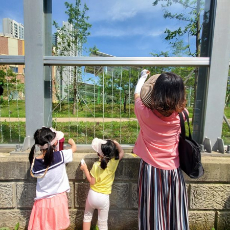유리 방음벽에 스티커를 붙이고 있는 엄마와 아이들. 생명을 살리고 함께 살아가는 걸 알려주는 데에, 이보다 더 좋은 교육이 있을까 싶다./사진=녹색연합