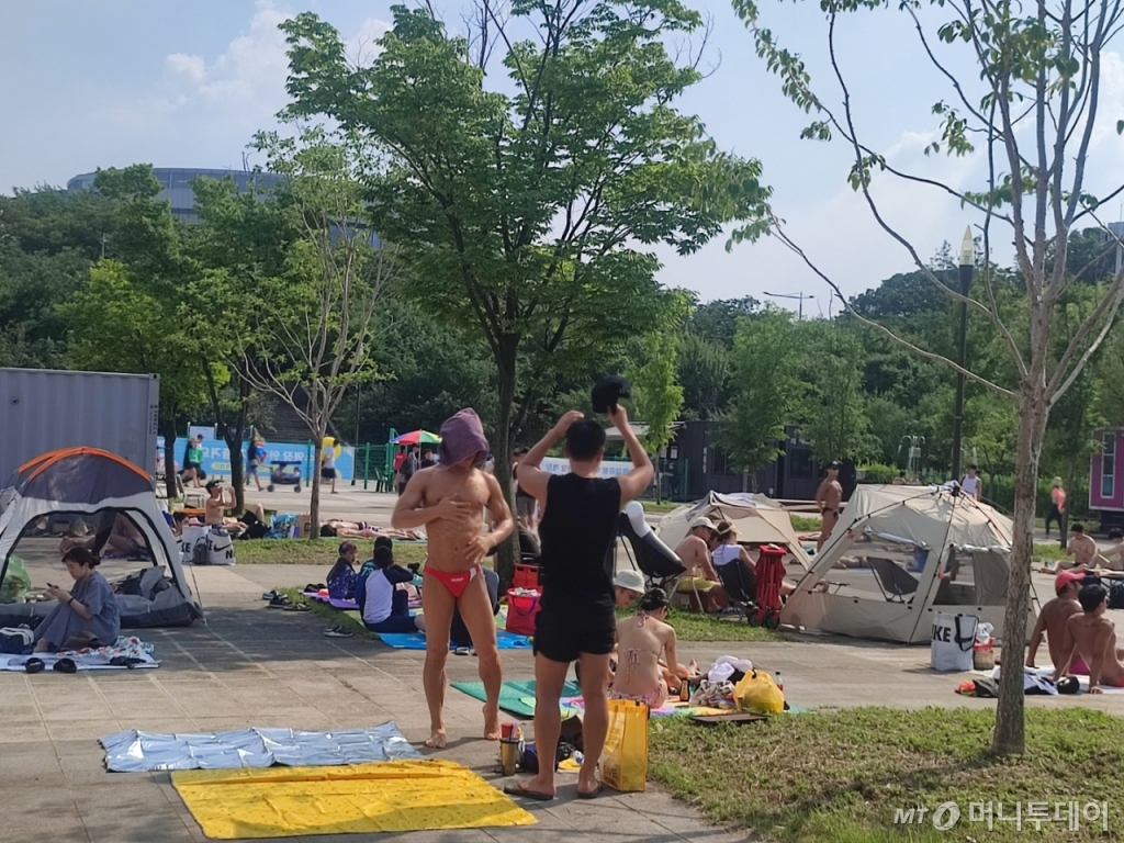 3일 오후 서울 영등포구 여의도 한강수영장에서 방문객들이 태닝을 즐기고 있다. /사진=정세진 기자