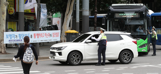 횡단보도 앞 일시정지 등 보행자 보호 의무를 강화한 도로교통법 개정안 시행 첫날인 12일 서울 종로구 이화사거리에서 경찰들이 계도에 나서고 있다. /사진=뉴스1  