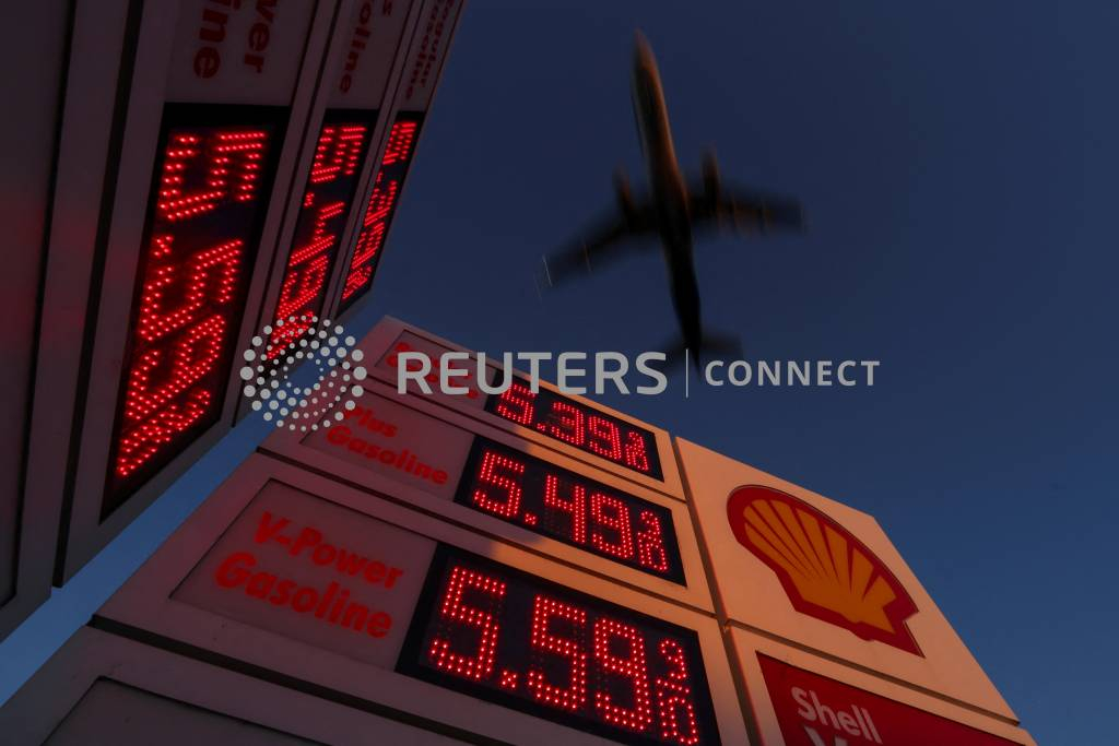 An aircraft flies over a sign displaying current gas prices as it approaches to land in San Diego, California, U.S., February 28, 2022. REUTERS/Mike Blake/File Photo/사진=로이터=뉴스1