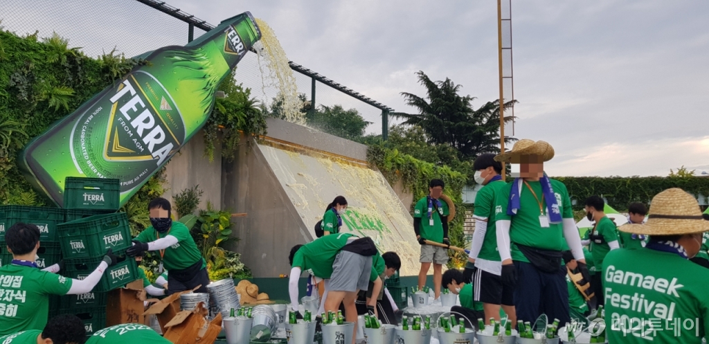 맥주 댐처럼 꾸며진 테라 맥주 판매 부스에서 자원봉사자 '가맥지기'와 하이트진로 직원 등이 맥주를 운반하고 있다./사진= 박미주 기자