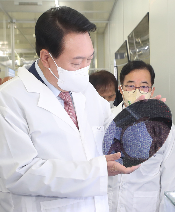 (대전=뉴스1) 인수위사진기자단 = 윤석열 대통령 당선인이 29일 오전 대전 유성구 카이스트 부설 나노종합기술원을 방문해 반도체 웨이퍼를 살펴보고 있다. 2022.4.29/뉴스1  