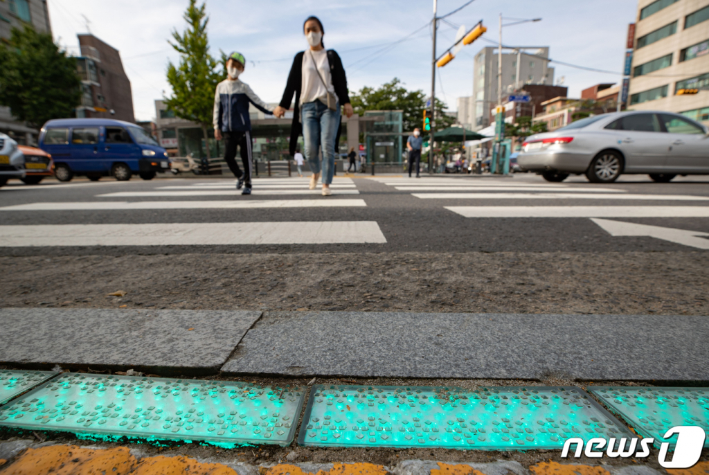 (서울=뉴스1) 이재명 기자 = 21일 오전 서울 중구 청구역 앞 스쿨존에 설치된 LED 바닥 신호등 앞으로 한 어린이가 등교하고 있다.   중구는 LED 바닥 신호등은 안전한 보행환경 조성을 위해 어린이보호구역 및 지하철역 횡단보도 19개소에 설치했다. 2020.9.21/뉴스1  