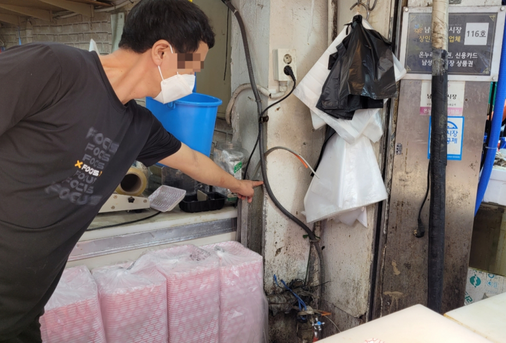 5일 오후 3시쯤. 서울 동작구 사당동 남성시장의 한 정육점에서 일하는 윤재평씨(38)가 벽을 가리키며 지난달 폭우로 물이 들어찬 높이를 알려주고 있는 모습./사진=김도균 기자