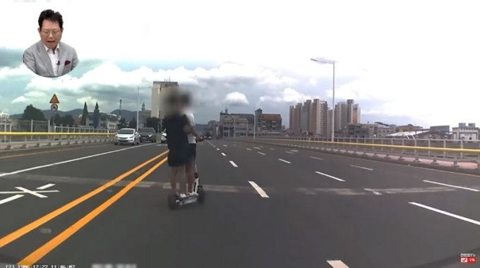 안전모를 쓰지 않은 채 전동킥보드에 올라탄 남성 2명이 왕복 6차선 도로를 가로지르는 아찔한 상황이 공개됐다. /사진=유튜브 한문철TV 