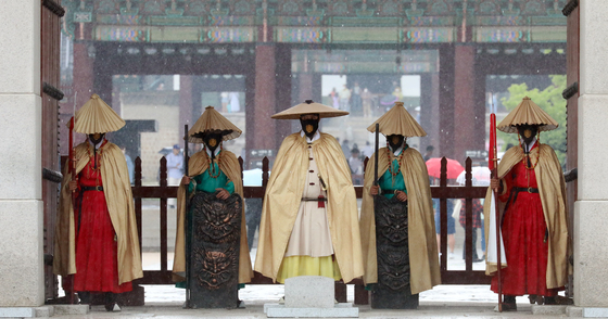(서울=뉴스1) 김명섭 기자 = 갑작스런 소나기가 내린 9일 오후 서울 광화문 수문장들이 전통 비옷을 입고 있다. 2022.6.9/뉴스1  