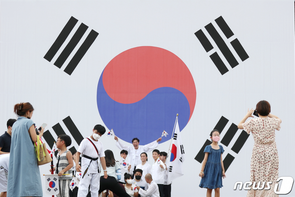 (서울=뉴스1) 민경석 기자 = 제77주년 광복절을 하루 앞둔 14일 오전 서울 서대문구 서대문형무소역사관을 찾은 시민들이 대형 태극기 앞에서 공연단과 함께 기념촬영을 하고 있다. 2022.8.14/뉴스1  Copyright ? 뉴스1. All rights reserved. 무단 전재 및 재배포 금지.