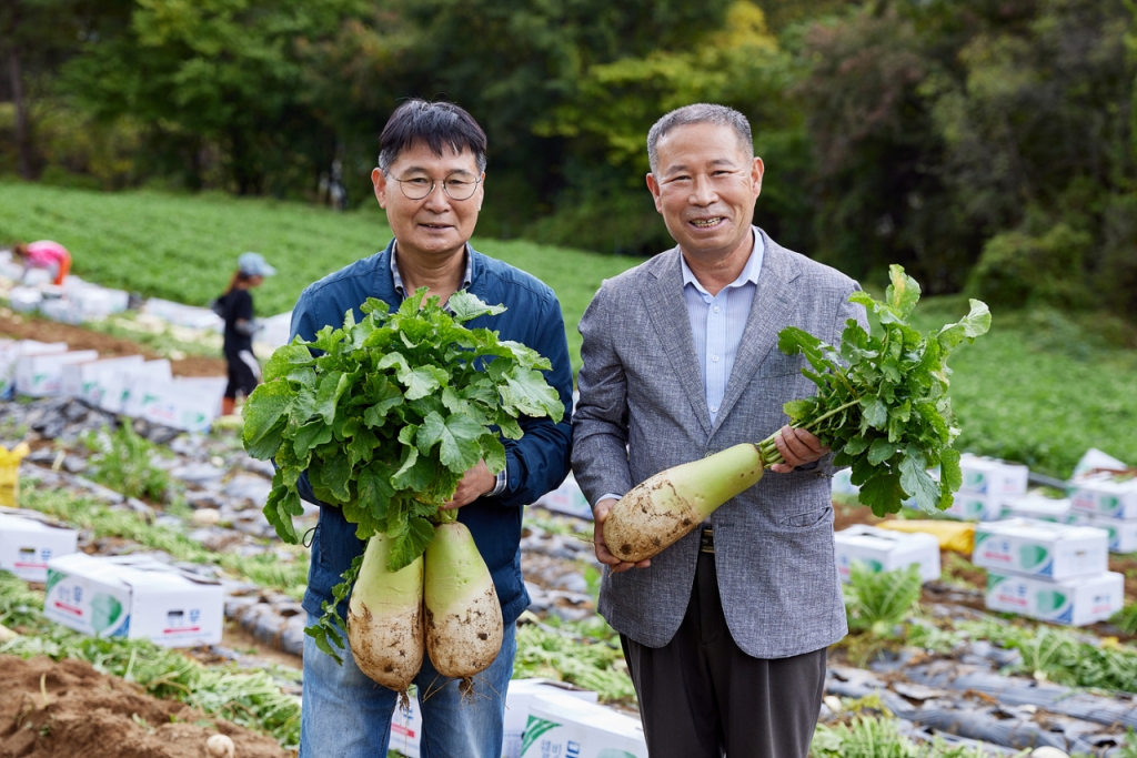 지난 6일 최인규 농가에서 최인규 농장주(왼쪽)와 김필곤 부광 대표(오른쪽)가 수확한 무를 들고 있는 모습/사진제공= 홈플러스