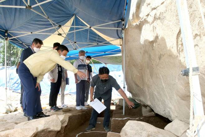 허성곤 전 김해시장(왼쪽)이 구산동 지석묘 발굴조사 현장을 찾아 지석묘 아래를 살펴보고 있다.2021.07./사진제공=김해시 허성곤 전 김해시장(왼쪽)이 구산동 지석묘 발굴조사 현장을 찾아 지석묘 아래를 살펴보고 있다.2021.07./사진제공=김해시