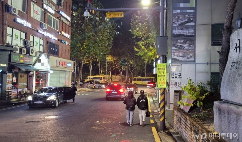 2023학년도 대학수학능력시험이 치러진 17일 오후 9시쯤 서울 강남구 대치동 학원가에서 재수생 B씨(19)가 체대입시 학원에 들러 선생님을 만나고 귀가하고 있다. A씨는 이날 점심에 먹은 도시락을 손에 들고 있었다. /사진=김도균 기자