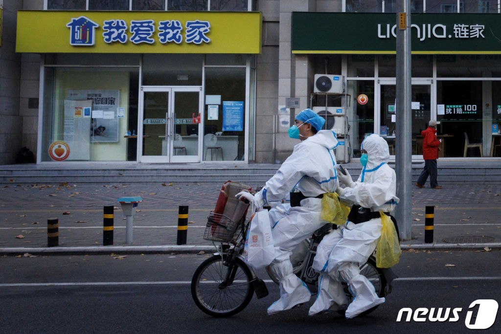 (베이징 로이터=뉴스1) 최종일 기자 = 동절기에 접어들면서 중국에서 6개월 만에 처음으로 사망자가 발생하는 등 코로나19가 창궐하고 있는 가운데 방역 요원들이 방역복을 입은 채 전기 자전거를 타고 이동하고 있다.   ⓒ 로이터=뉴스1  Copyright ? 뉴스1. All rights reserved. 무단 전재 및 재배포 금지.