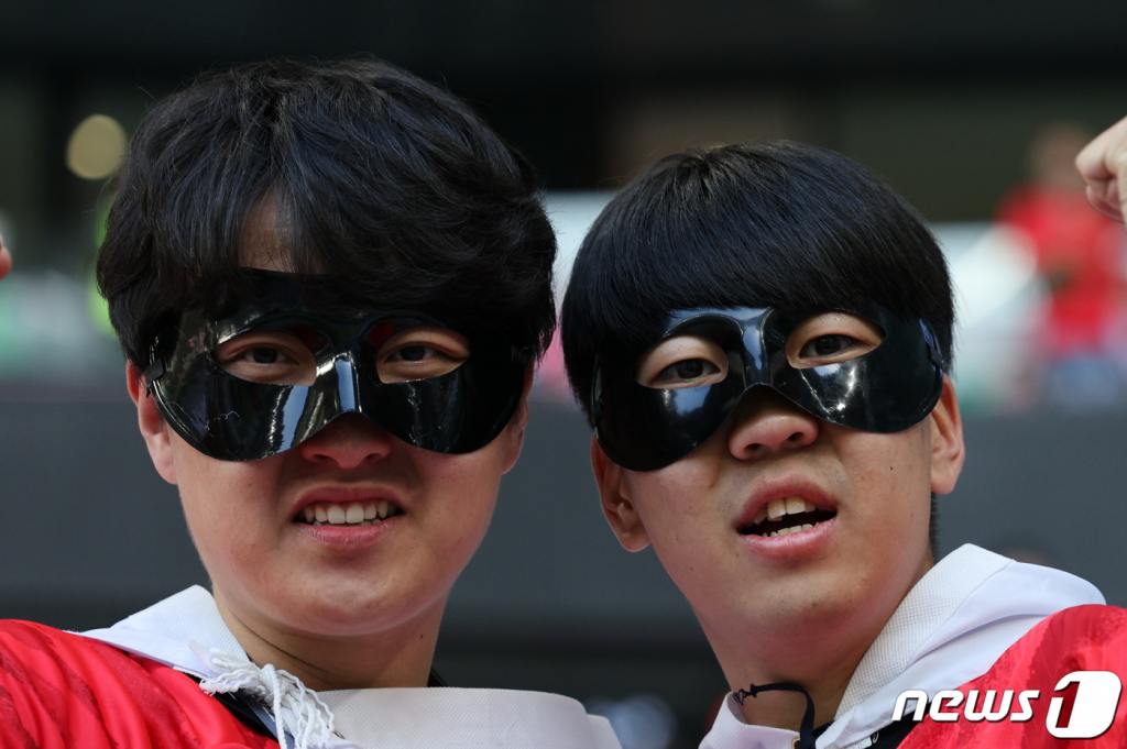 (도하(카타르)=뉴스1) 이동해 기자 = 24일 오후(현지시간) 카타르 알라이얀 에듀케이션 시티 스타디움에서 열리는 2022 카타르 월드컵 조별리그 H조 1차전 우루과이와의 경기를 찾은 축구팬들이 캡틴 손흥민이 착용한 안면 마스크를 착용한 채 취재진을 바라보고 있다. 2022.11.24/뉴스1  Copyright ? 뉴스1. All rights reserved. 무단 전재 및 재배포 금지.