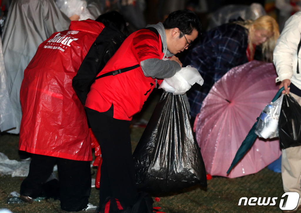 붉은악마와 시민들이 28일 밤 서울 광화문광장에서 2022 카타르 월드컵 H조 조별리그 2차전 대한민국과 가나의 경기 응원을 마치고 쓰레기를 치우고 있다./사진=뉴스1