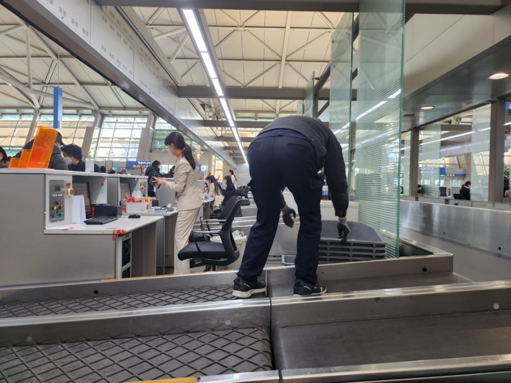 지난달 22일 오전 9시 인천국제공항 직원이 제주공항 카운터 뒤에 짐 보관용 바구니를 놓고 있다. /사진=정한결 기자.