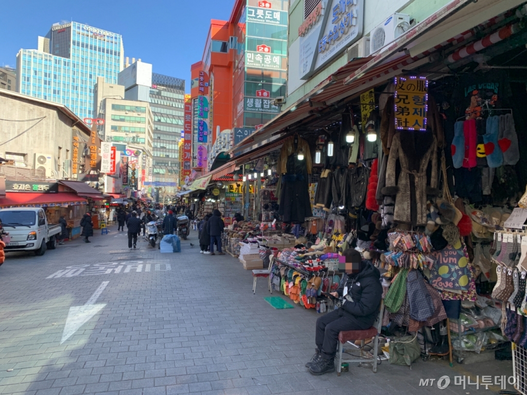 20일 오전 11시 서울 중구 남대문시장의 중심거리. 남대문시장에서 30년 넘게 옷가게를 운영한 신종철씨(75)가 한산한 거리에 앉아 휴대전화를 바라보고 있다./사진=김도엽 기자 