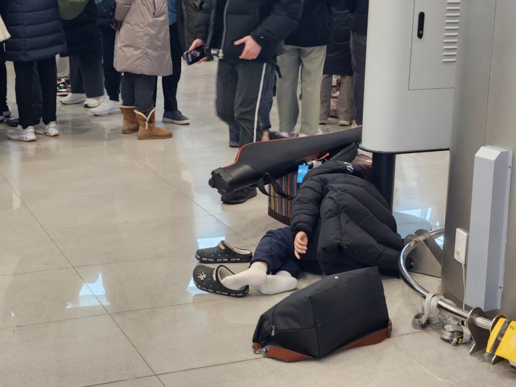 24일 오전 5시30분쯤 제주공항 3층에서 한 아이가 기다림에 지친 듯 공항 바닥에 누워있었다./사진=박상곤 기자