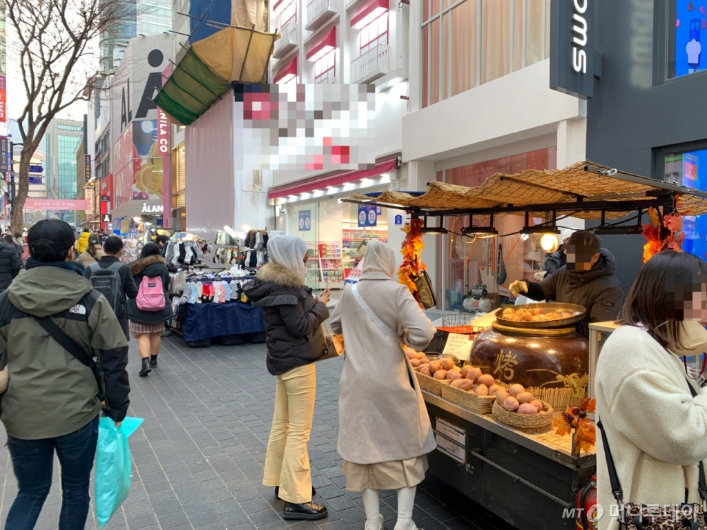 7일 오후 4시 서울 중구 명동 거리. 히잡을 착용한 이슬람권 관광객들이 명동 노점상에게 음식을 구매하고 있다./사진=김도엽 기자 