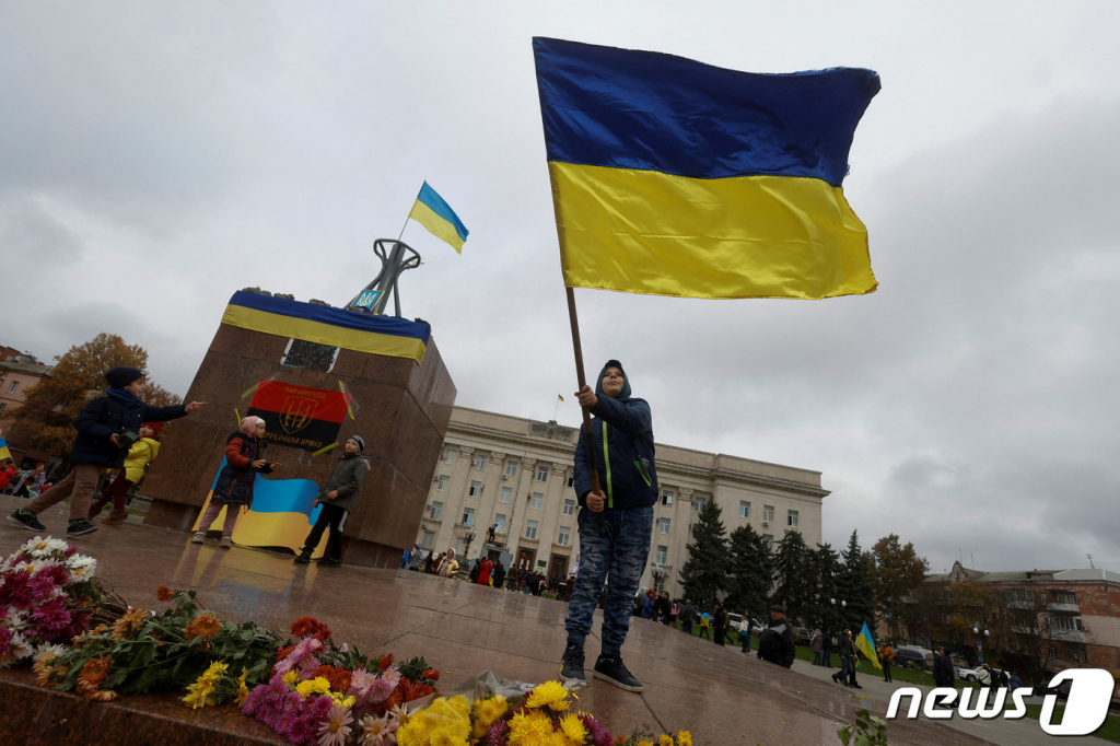 (헤르손 로이터=뉴스1) 정윤미 기자 = 13일(현지시간) 우크라이나 남부 헤르손 중심부에서 한 남성이 우크라이나 깃발을 흔들고 있다. 그는 지난 2월24일 러시아 침공 이래 점령 당했던 헤르손 해방을 기념하고 있다고 로이터통신이 보도했다. 2022.11.13  ⓒ 로이터=뉴스1  Copyright ? 뉴스1. All rights reserved. 무단 전재 및 재배포 금지.