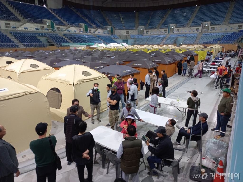 13일 오후 강원도 강릉시 아레나 경기장 안에서 주민들이 추진위원회를 둘러싸고 이야기 나누는 모습. /사진=김지은 기자 