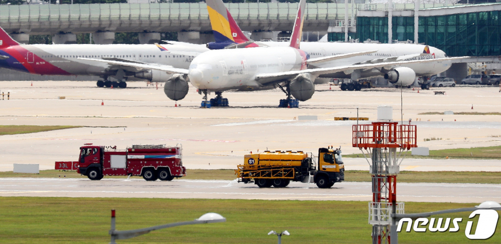 (인천공항=뉴스1) 박지혜 기자 = 무더운 날씨가 계속된 7일 오후 인천국제공항에서 살수차와 소방차가 더위를 식히기 위해 활주로에 살수작업을 하고 있다. 2021.8.7/뉴스1
