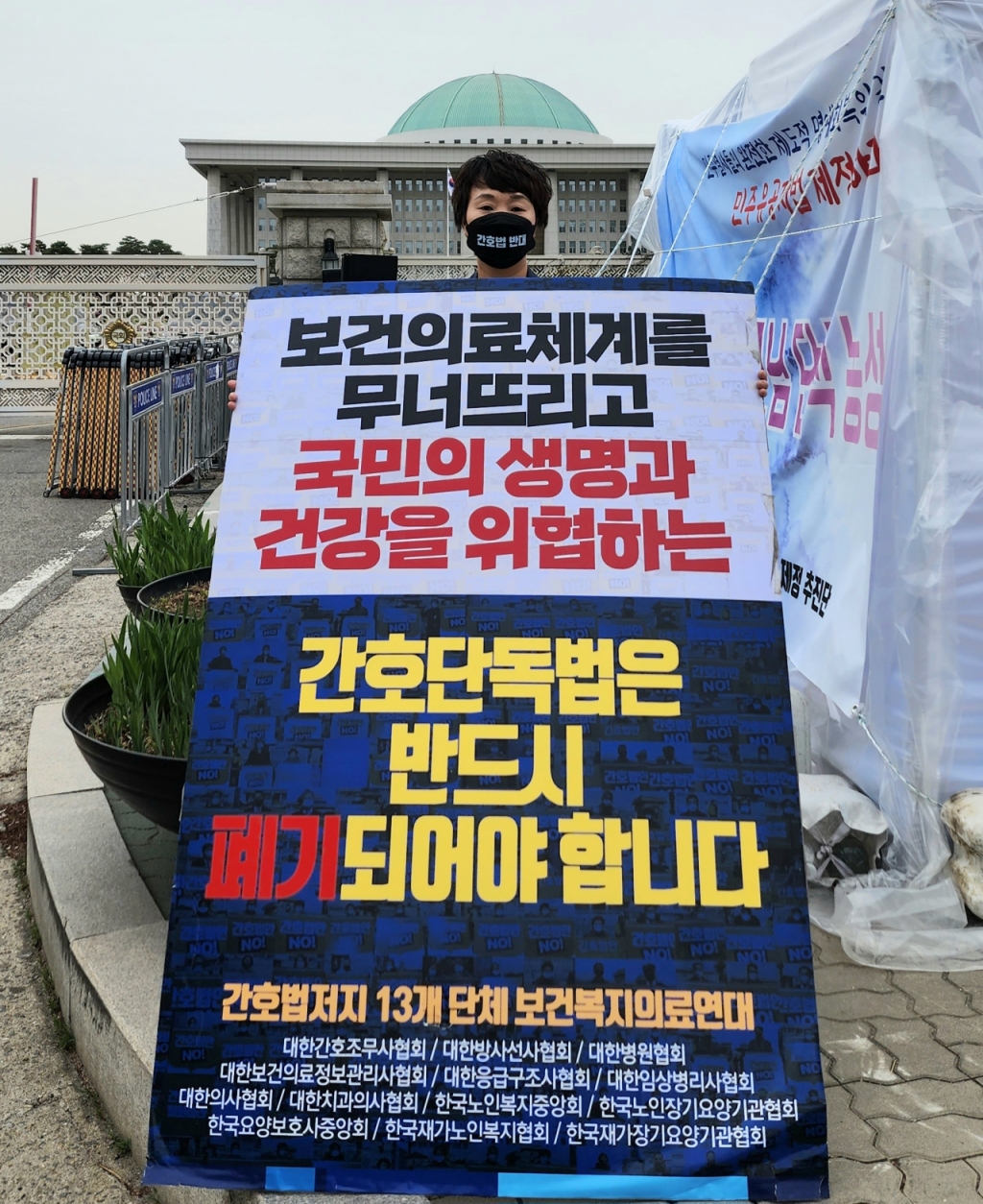간호법 상정을 둘러싼 국회 본회의 표결이 당초 예고된 13일, 서울 여의도 국회의사당 앞에서 곽지연 대한간호조무사협회장이 마지막 피켓시위에 나서고 있다. /사진=정심교 기자