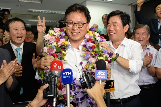 = (수원=뉴스1)박지혜 기자 = 새정치민주연합 수원정 박광온 후보가 30일 경기도 수원시 영통구 선거사무소에서 당선이 확정되자 꽃다발을 목에 걸고 환하게 웃고 있다. 2014.7.30/뉴스1