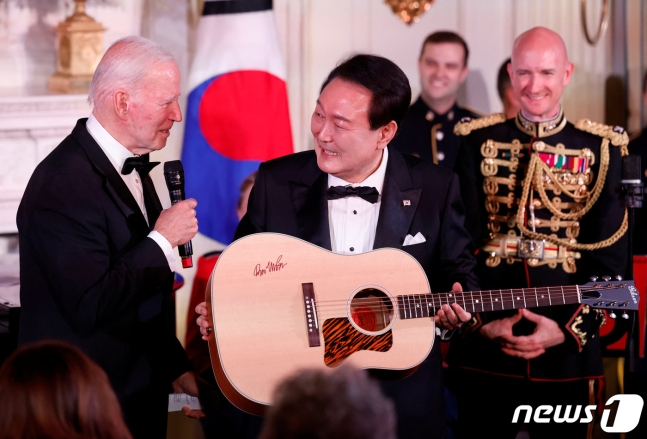 조 바이든 미국 대통령이 26일(현지시간) 백악관 국빈만찬에서 윤석열 대통령에게 가수 돈 맥클린의 친필 사인이 담긴 통기타를 선물했다. ⓒ 로이터=뉴스1