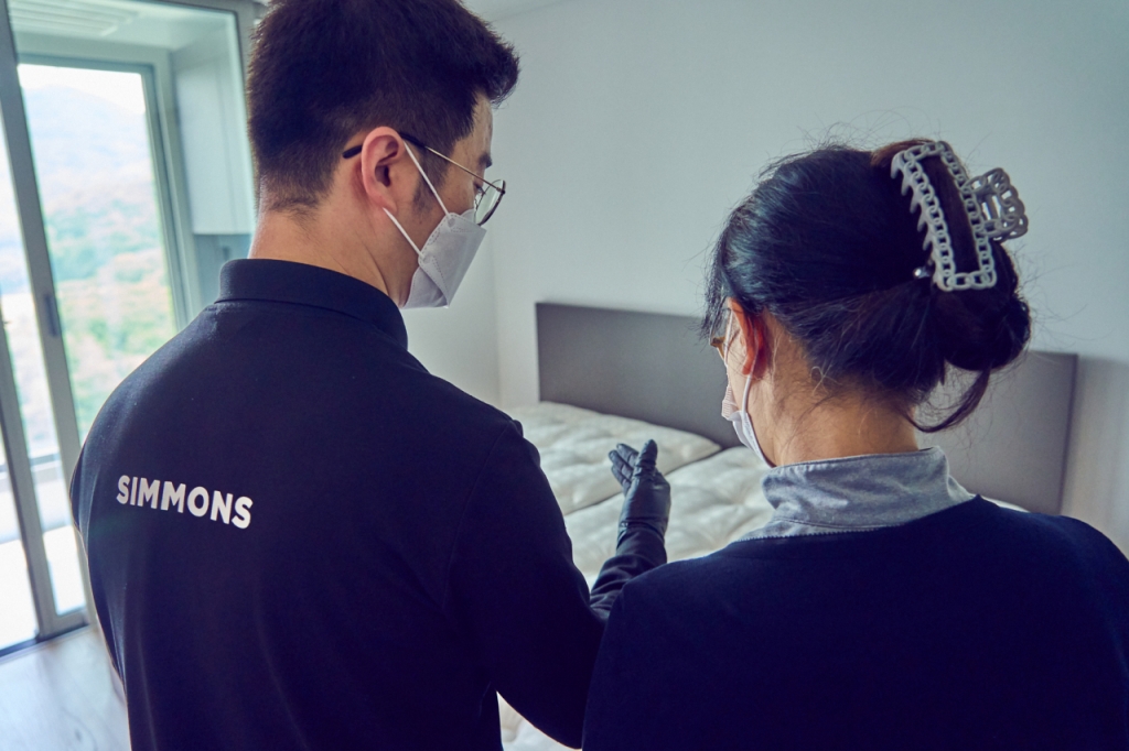 침대 배송을 마치고 시몬스 배송 매니저가 고객에게 매트리스 관리법 등을 설명하고 있다./사진제공=시몬스.