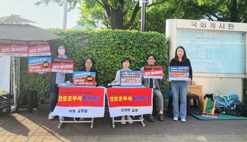 정연(왼쪽 테이블) 전국직업계고 간호교육교장협의회장, 김희영(오른쪽 테이블) 고등학교간호교육협회장 등 특성화고교 교사들이 9일 서울 여의도 국회의사당 앞 이동식 교실에서 쉬는 시간에 피켓 시위를 진행하고 있다. /사진=주최 측