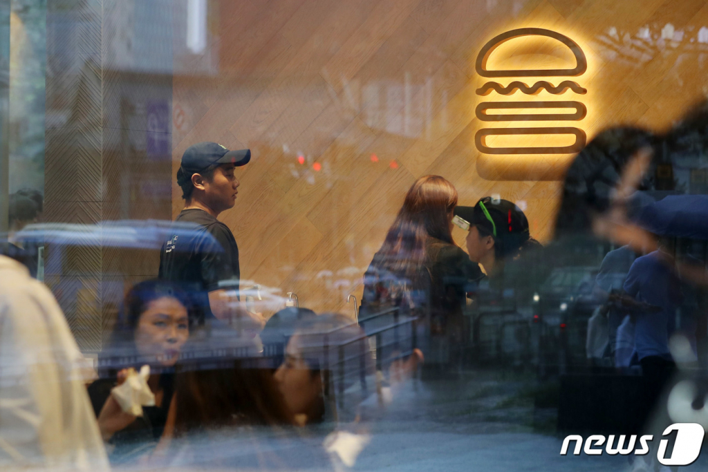 (서울=뉴스1) 이동해 기자 = 29일 오전 서울 종로구 그랑서울 빌딩에 위치한 미국의 프리미엄 수제버거 '쉐이크쉑' 10호점 매장에서 고객들이 햄버거를 먹고 있다.  국내 10번째 매장인 ‘쉐이크쉑 종각점’은 광화문, 경복궁, 세종대왕 동상, 숭례문 등 종로를 대표하는 장소를 쉐이크쉑 아이콘과 조합해 제작한 아트 그래픽으로 표현했다. 2019.8.29/뉴스1  