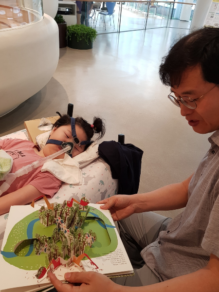 책을 읽어주는 아버지, 그 목소리를 듣고 쌔근쌔근 잠든 딸. 이 평범한 행복을 유지하게 해줄 치료제는 세상에 있으나, 그게 효과가 있는지 입증해야만 맞을 수 있다./사진=윤정호씨 제공