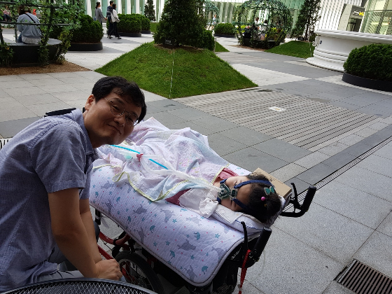 호흡기에 기대어 누워 있는 서연양과 그의 아버지 정호씨. 서연양은 척수성근위축증 1형 환자다. 호흡 근육이 약해 죽을 고비를 수도 없이 넘겼다. 그리고 살아 남았다. 그런 그에게 치료제를 계속 맞게 해주는 일, 그 기준은 그리 빡빡해야할지./사진=윤정호씨 제공