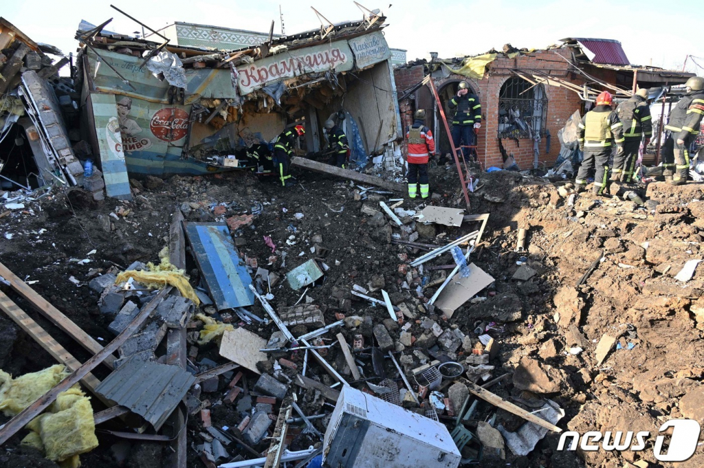 (셰브첸코브 AFP=뉴스1) 김성식 기자 = 9일(현지시간) 우크라이나 북동부 하르키이주(州) 셰브첸코브의 전통 시장이 러시아군의 폭격에 폐허로 변한 가운데 소방 대원들이 잔해에 깔린 시민들을 구조하고 있다. 현지 소방에 따르면 이번 폭격으로 중년 여성 2명이 숨지고 5명이 부상했다. 2023.1.9. ⓒ AFP=뉴스1 Copyright ? 뉴스1. All rights reserved. 무단 전재 및 재배포 금지.